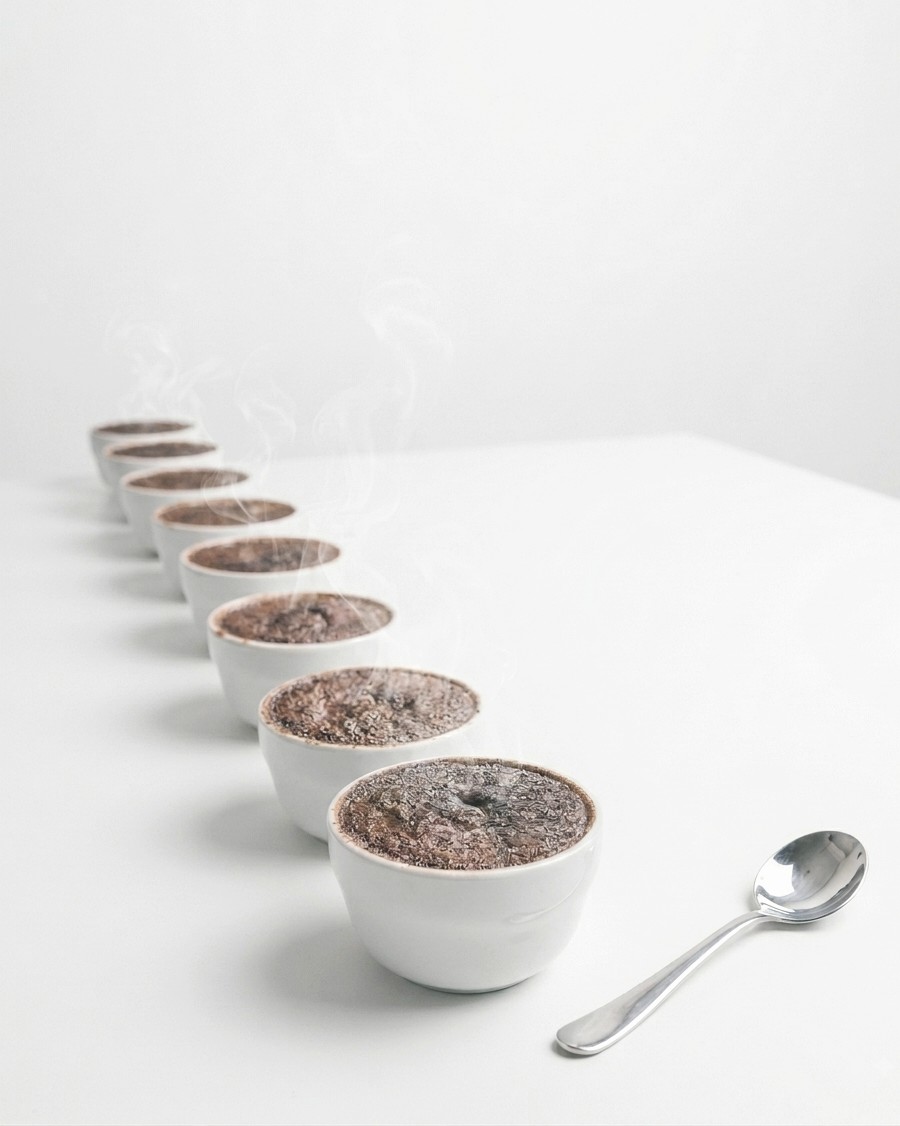 Cupping bowls in a line, steam rising, a cupping spoon beside them